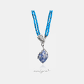 Double-strand blue beaded necklace with a crystal-set silver-tone panther head and a blue marbled stone pendant wrapped in branch-like silver.