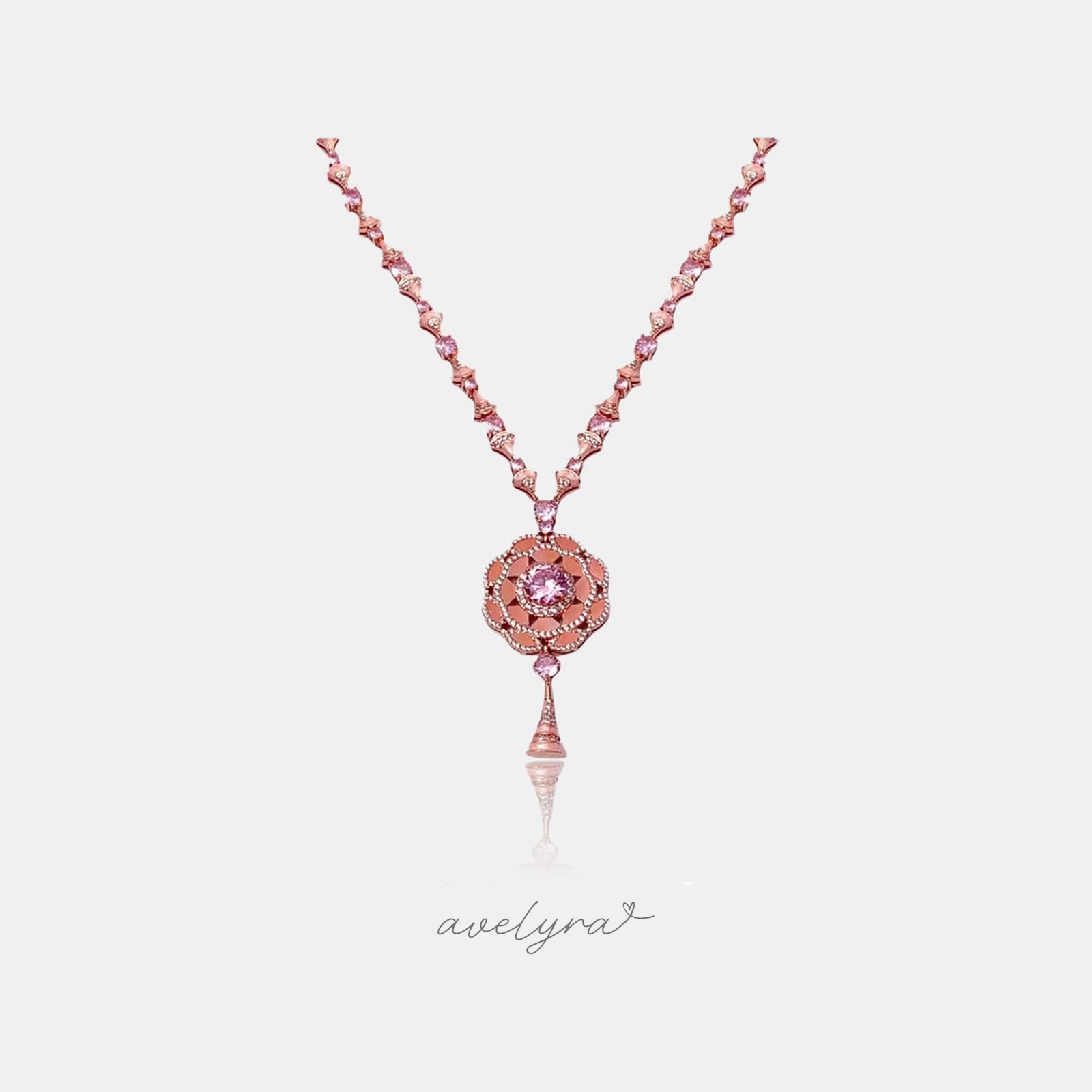 Rose-toned chain set with pink stones leading to a round tiered floral medallion pendant with a central pink stone and a tapered drop.