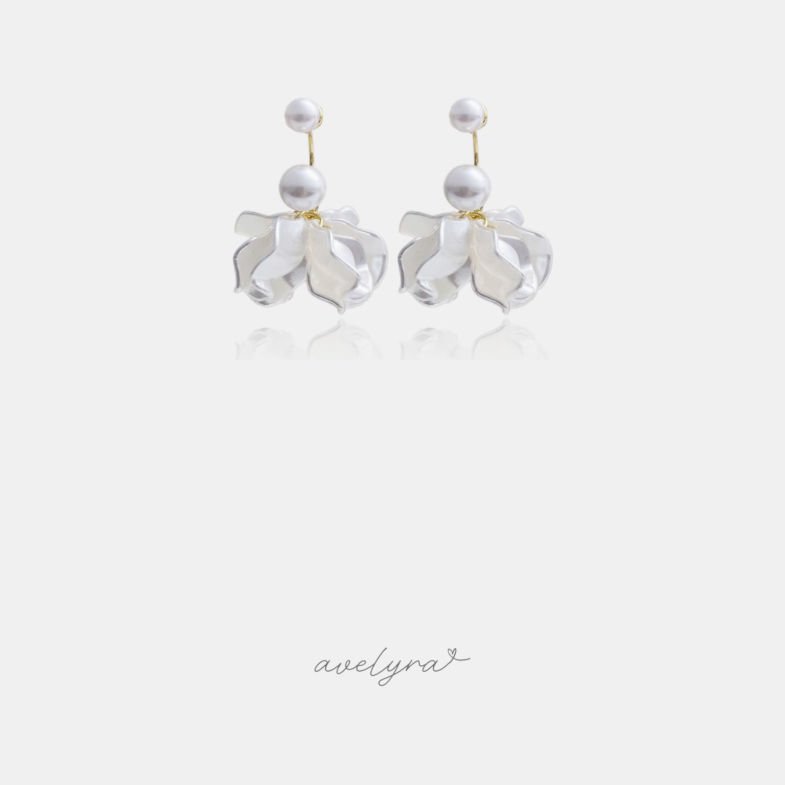Gold-tone drop earrings with two round white pearls above a cluster of ivory pearlescent petals.