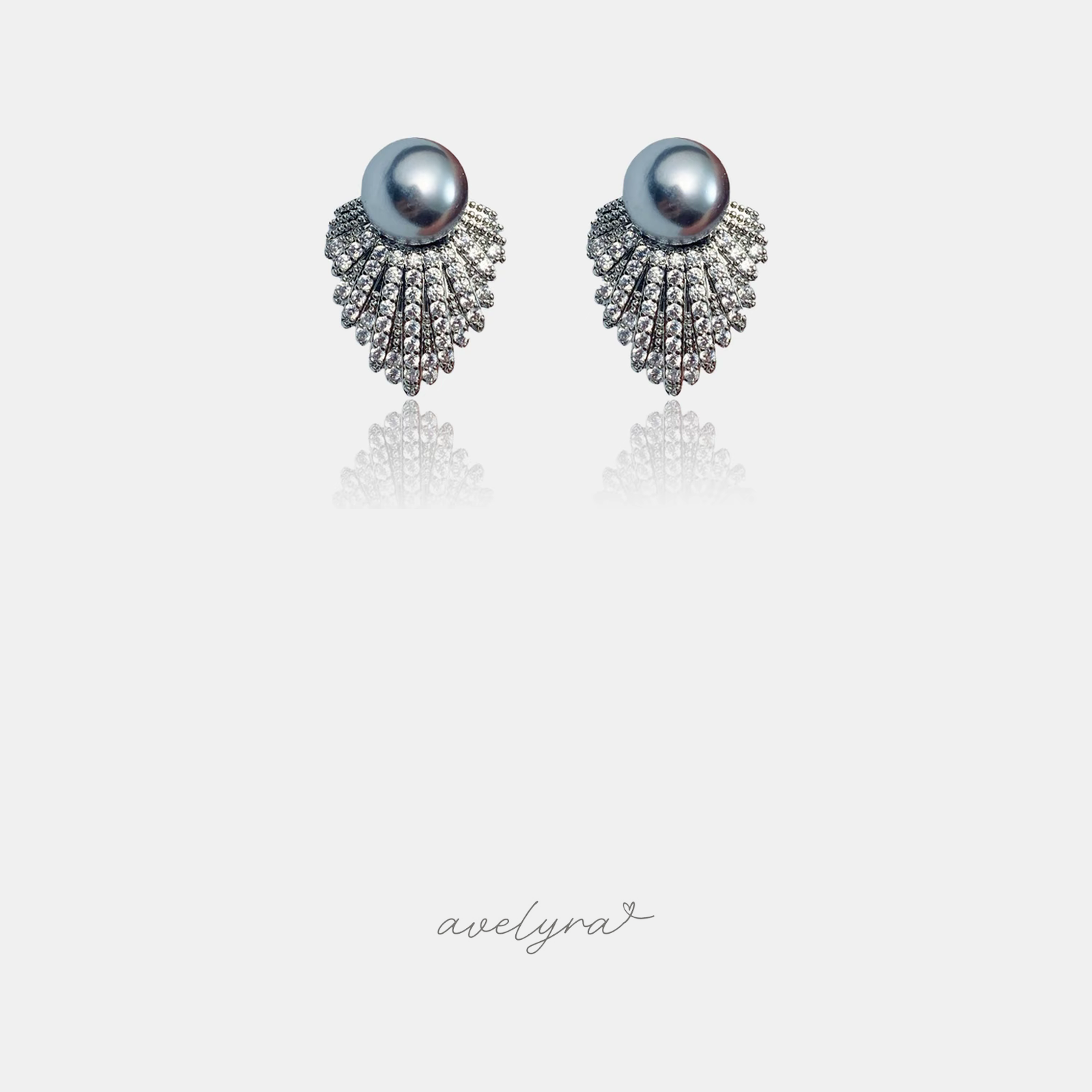 Pair of stud earrings with grey pearls above a fanned cluster of clear crystals.