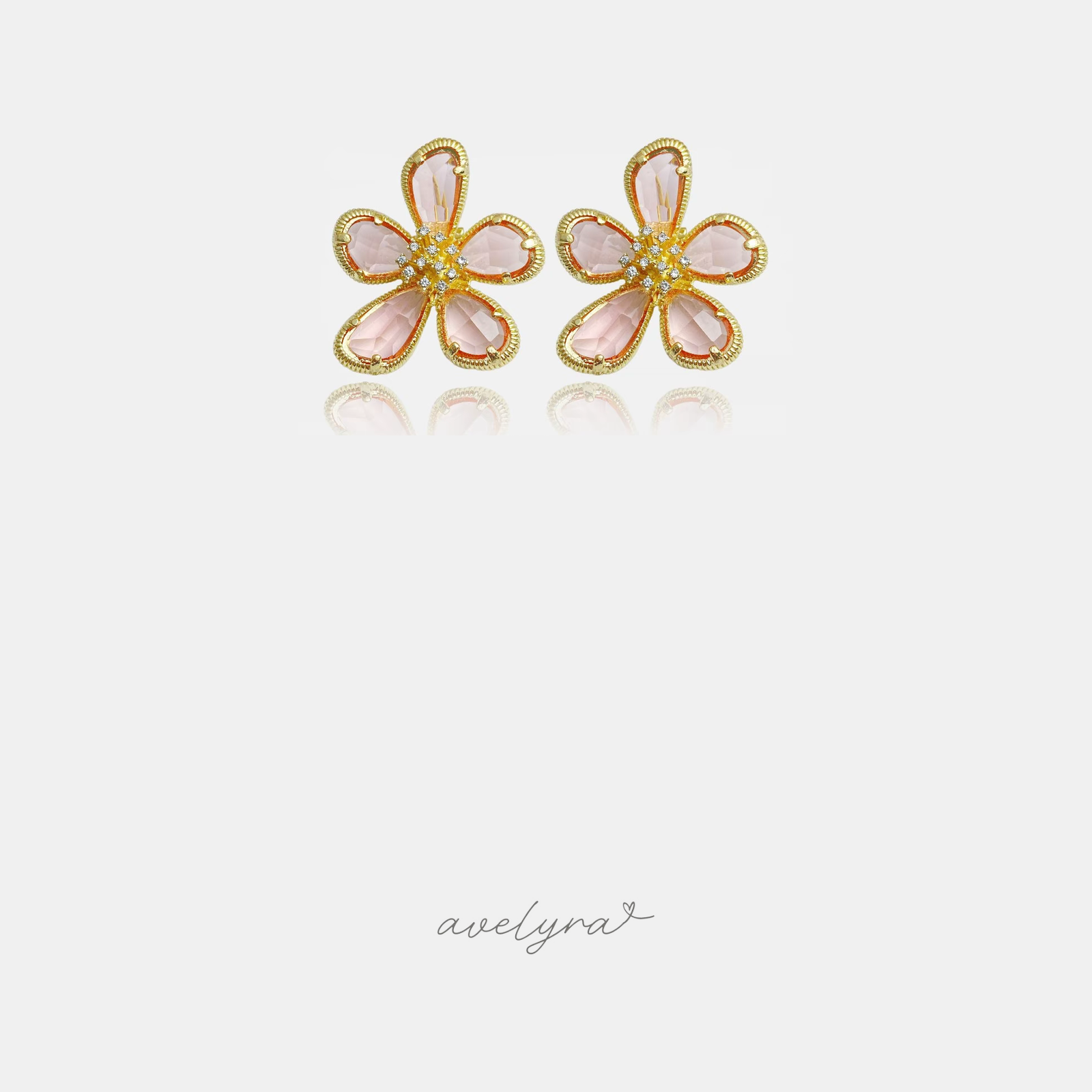 Pink five-petal flower stud earrings with gold-tone outlines and clustered crystals at the centre.
