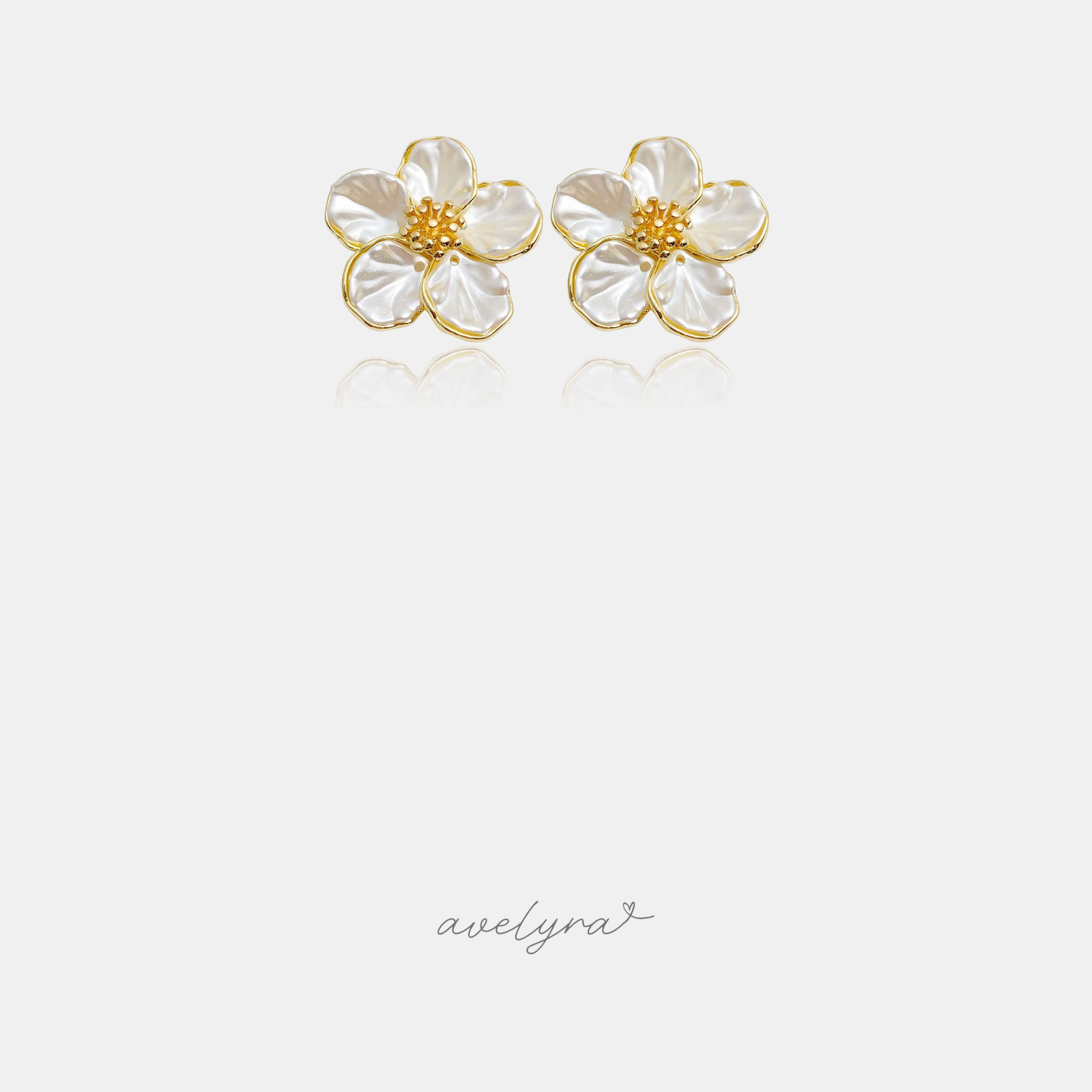 Pair of flower stud earrings with five pearly white sculpted petals around a textured gold centre.