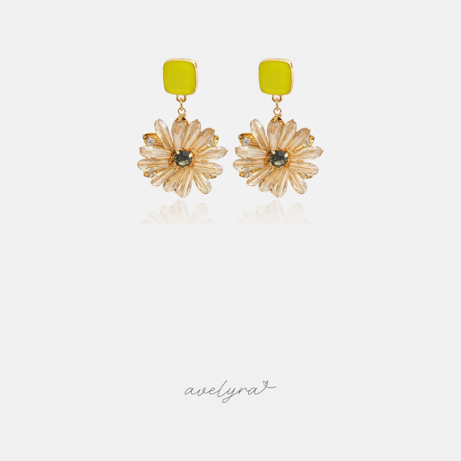 Pair of drop earrings with a yellow square stud above a champagne crystal flower with green centre.