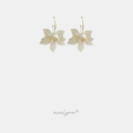 Drop earrings shaped as ivory pearlescent flower petals hanging from thin gold-tone hoop wires.