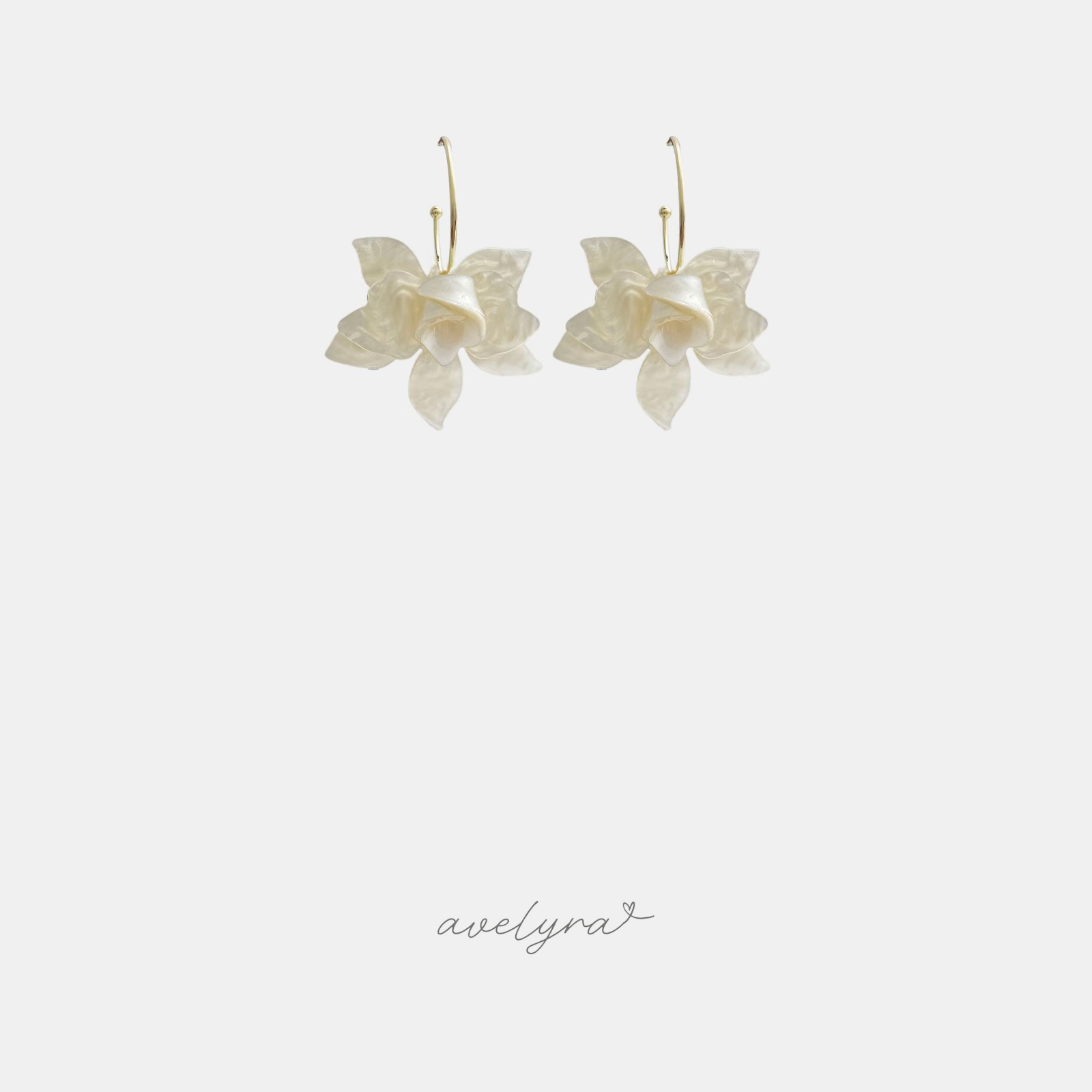 Drop earrings shaped as ivory pearlescent flower petals hanging from thin gold-tone hoop wires.