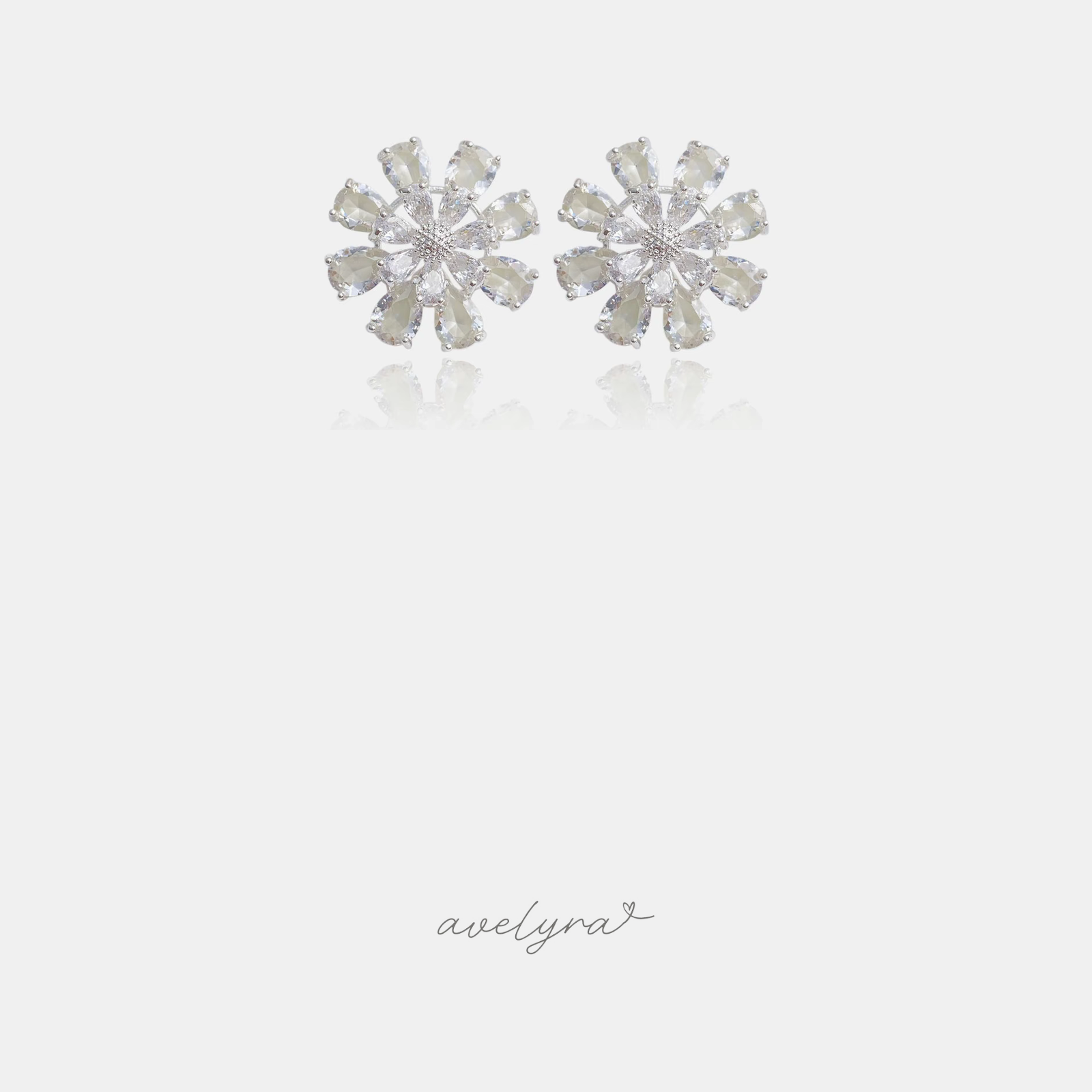 Flower stud earrings made of clear faceted teardrop stones radiating from the centre.