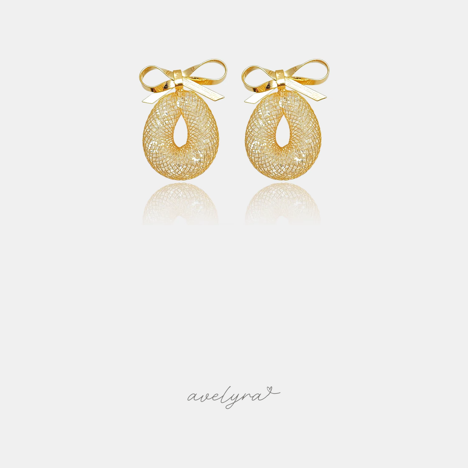 Gold bow earrings above an open woven-mesh oval drop.