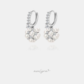 Pair of silver-tone huggie hoop earrings set with clear stones and a cluster of white pearls with small accent stones.