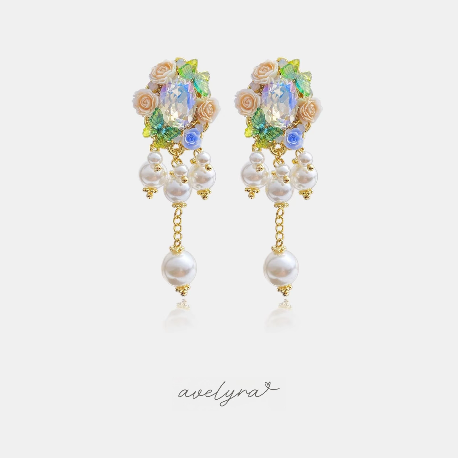 Gold-tone drop earrings with cream roses, an iridescent oval crystal and a cascade of white pearls