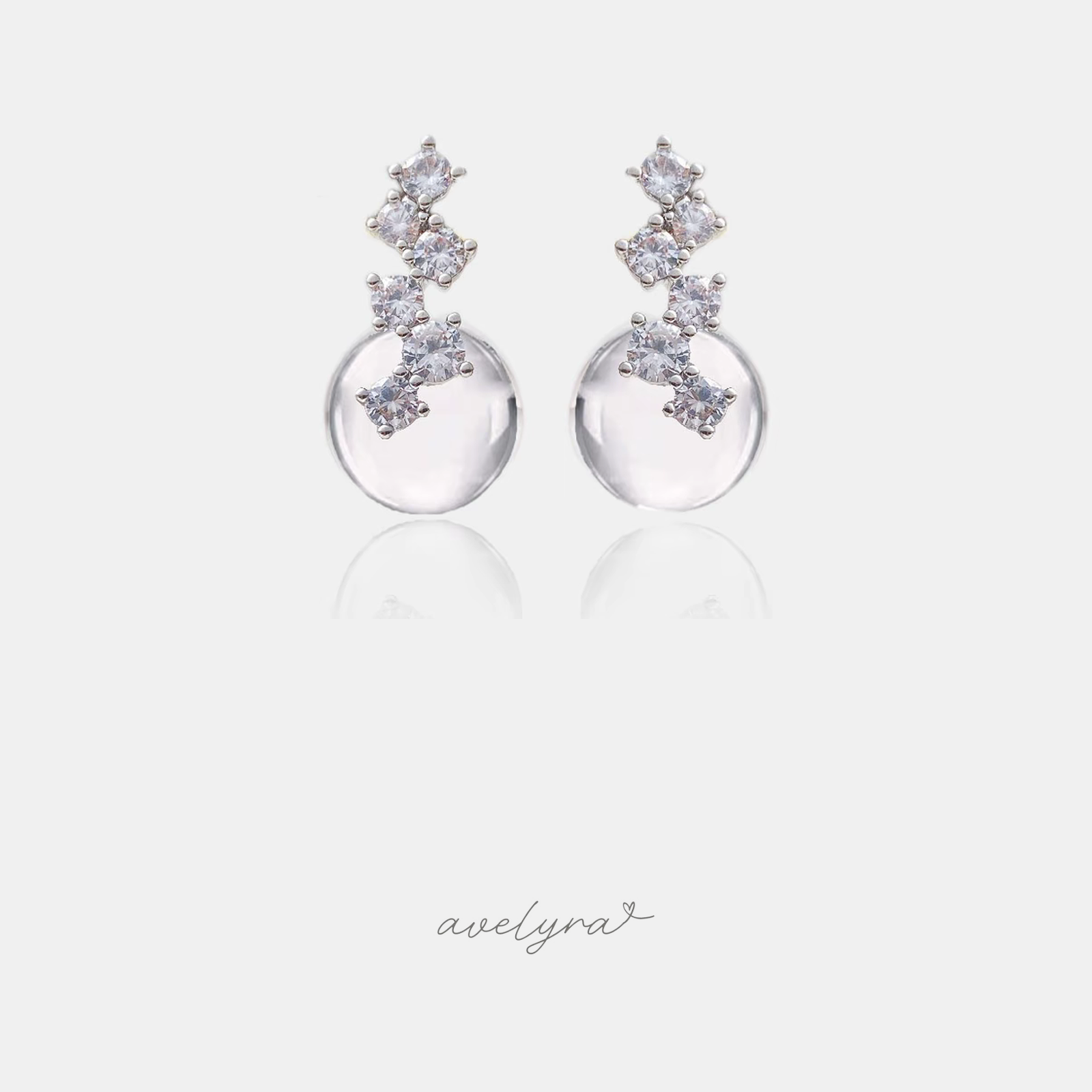 Silver-tone stud earrings with a cluster of small clear crystals set above a smooth round clear glass bead.