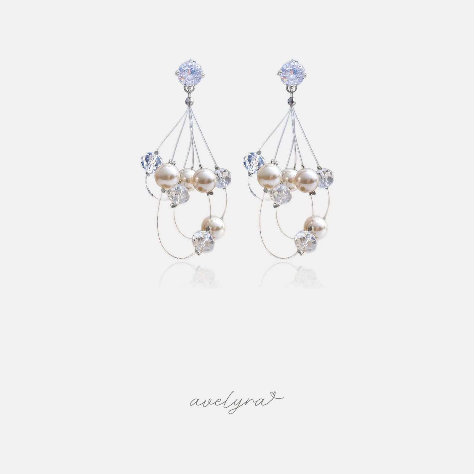 Silver-tone earrings with a round clear crystal top and a cluster of white pearls and clear crystal beads on fine looping wires.
