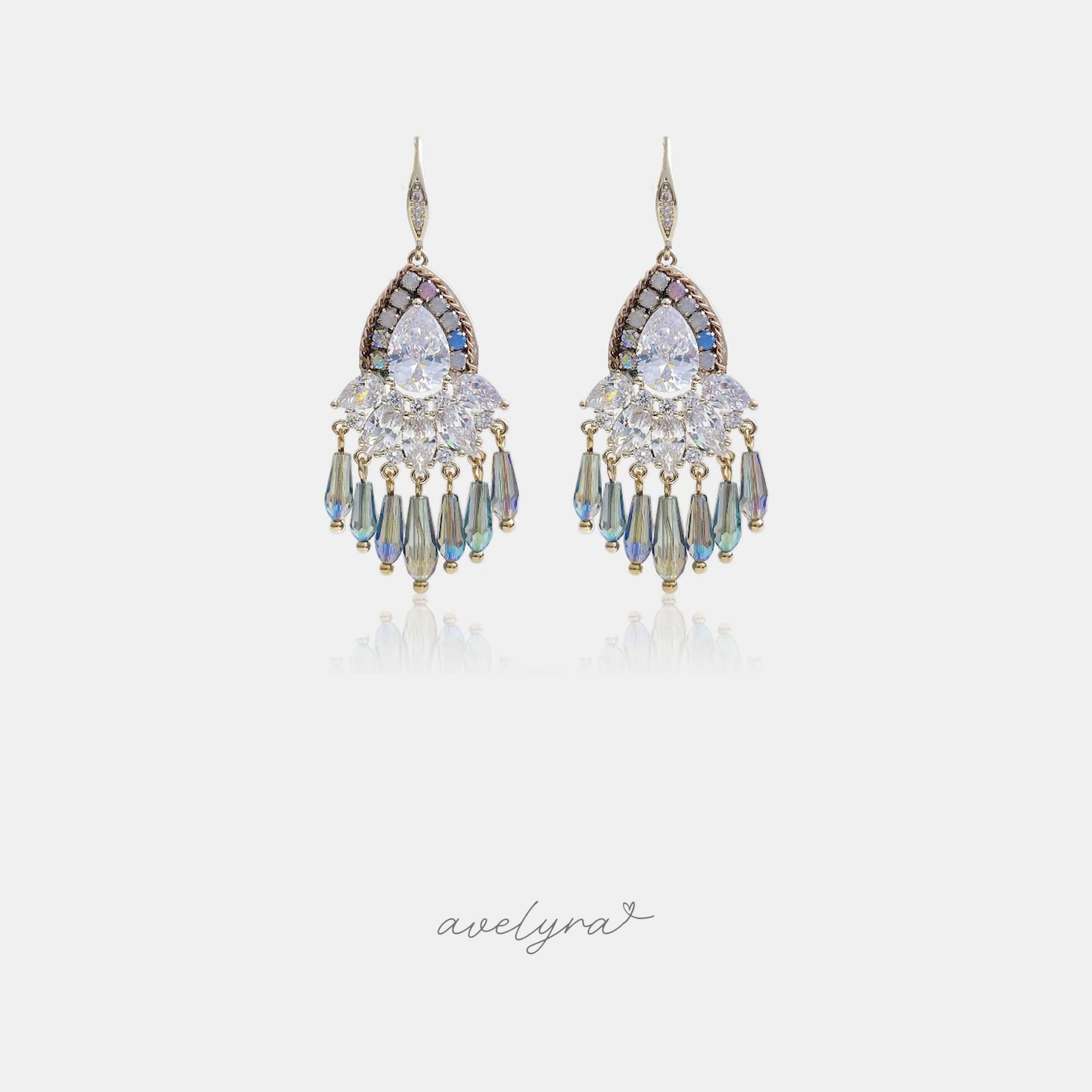 Silver-tone hook earrings with clear pear-shaped crystals above a fringe of iridescent blue-green droplet beads.