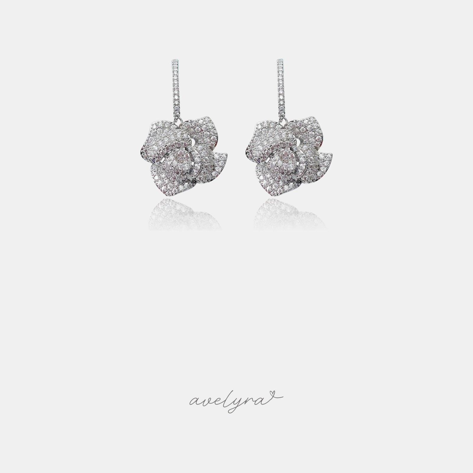 Pair of drop earrings shaped as crystal-pave silver roses on slim sparkling bars.