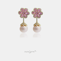 Pair of drop earrings with a pink crystal flower above a blush pearl in a petal-edged cap.