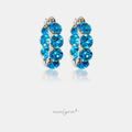 Pair of small silver huggie hoop earrings set with a row of round aqua-blue crystals.