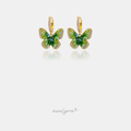 Green faceted butterfly charms edged with clear crystals, suspended from small pave gold-tone huggie hoops.