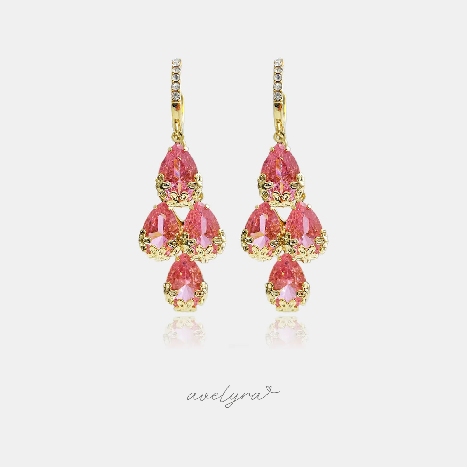 Gold-tone chandelier earrings with clusters of pink pear-shaped crystals hung from a crystal-lined top.