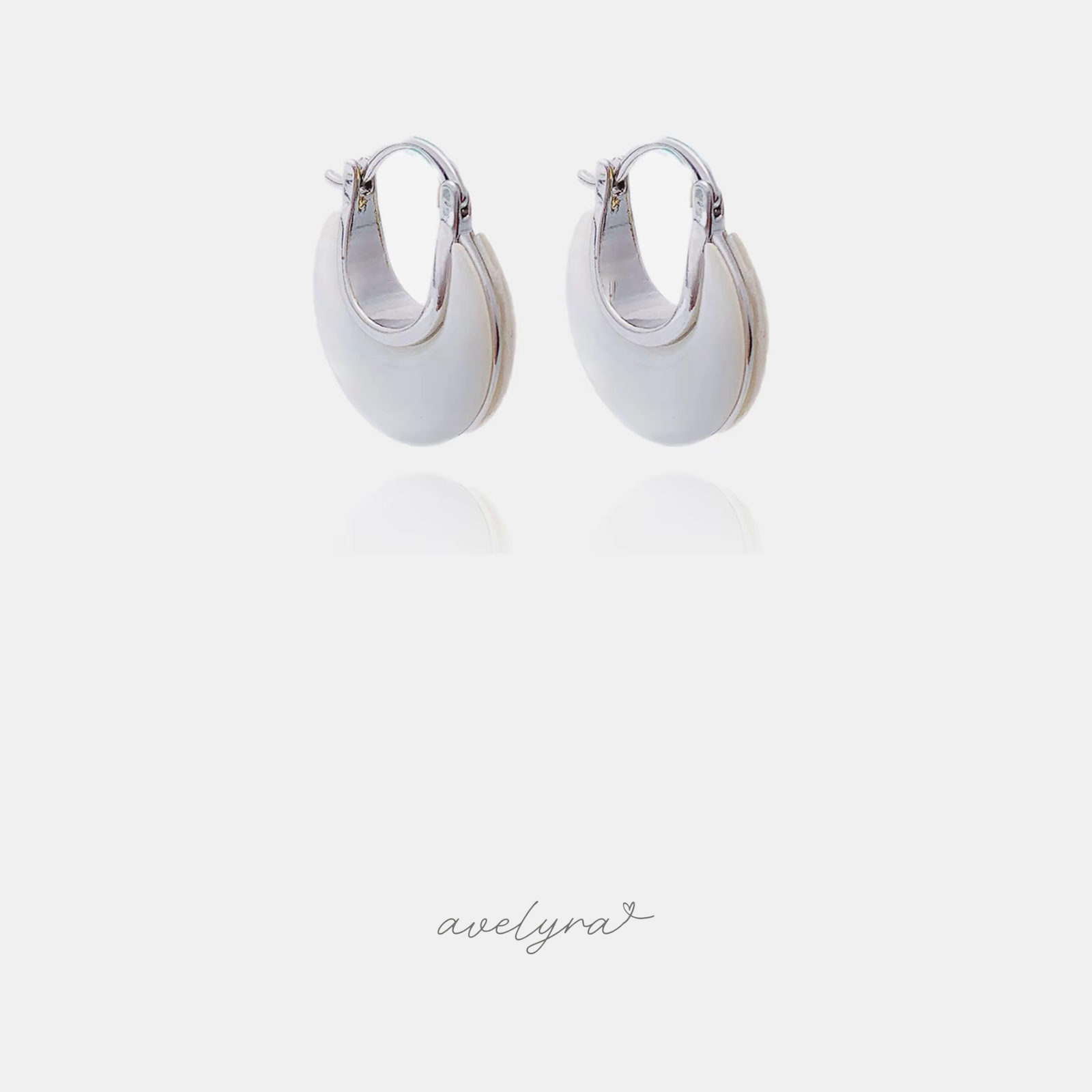 Chunky domed hoop earrings with smooth white surface and silver-tone edges.