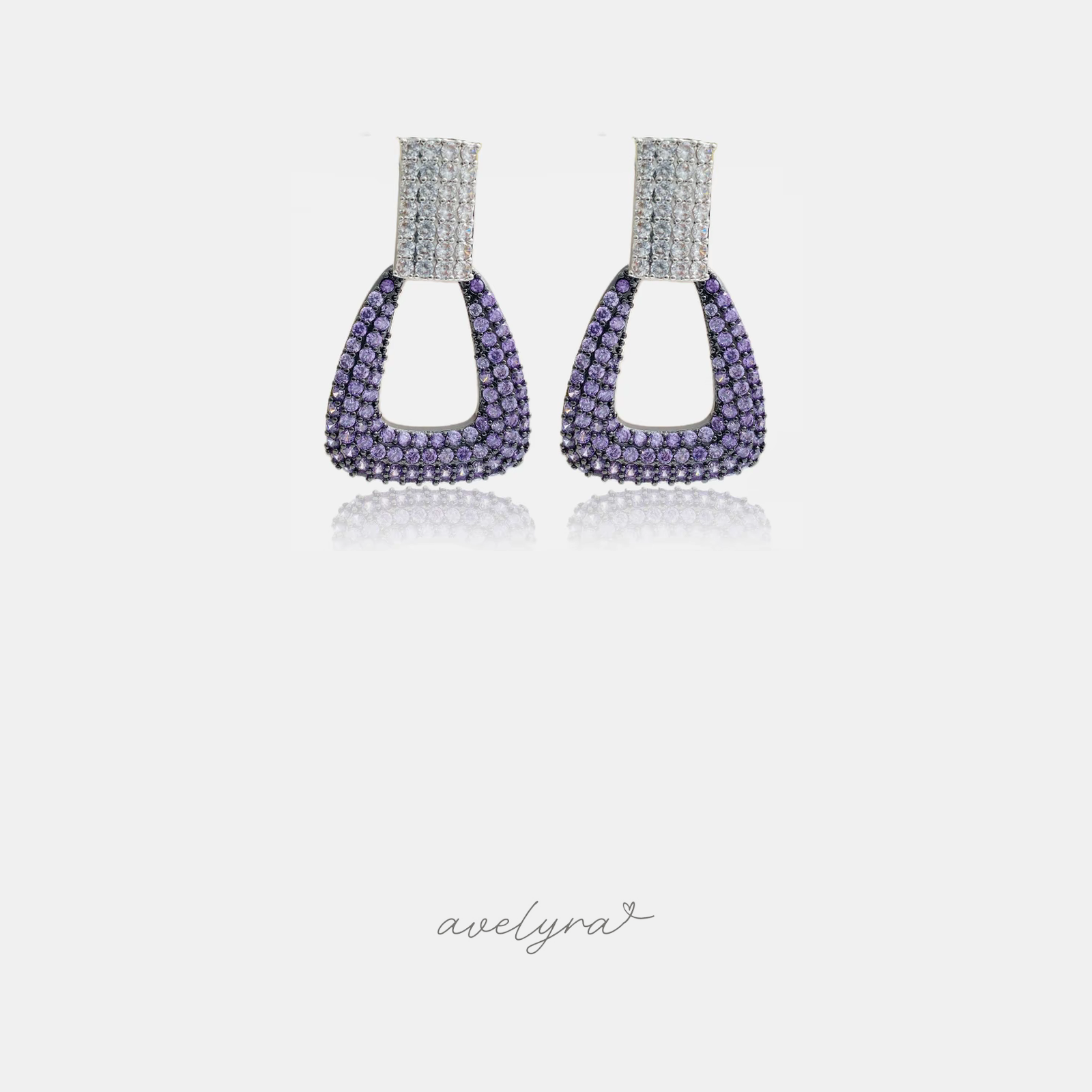 Doorknocker-shaped drop earrings paved with clear crystals at top and purple crystals below.