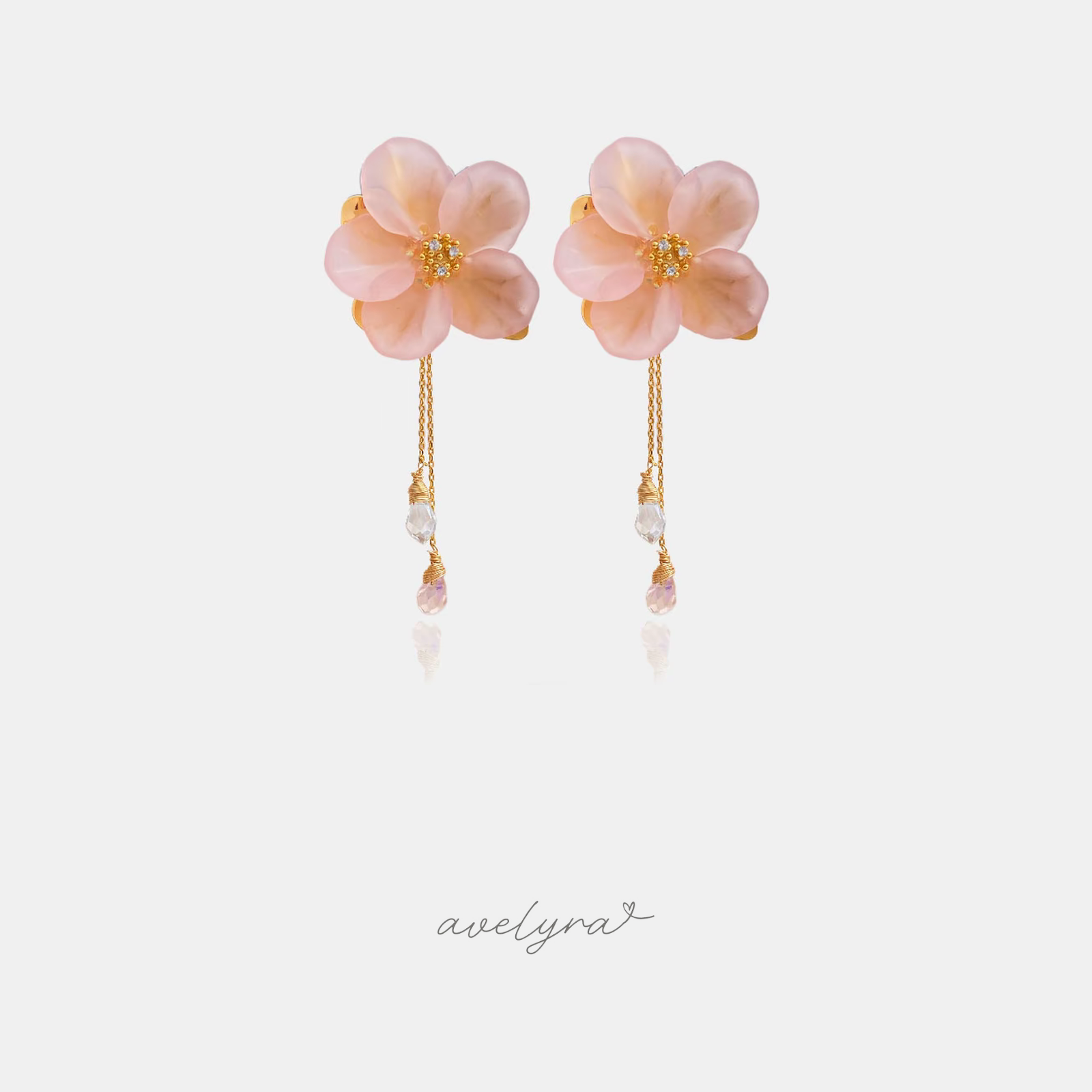 Pink flower earrings with golden centres and thin chains ending in clear and pink crystal droplets.