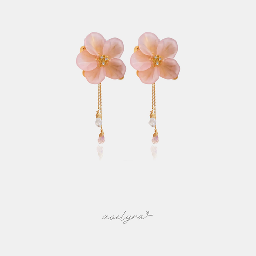 Pink flower earrings with golden centres and thin chains ending in clear and pink crystal droplets.