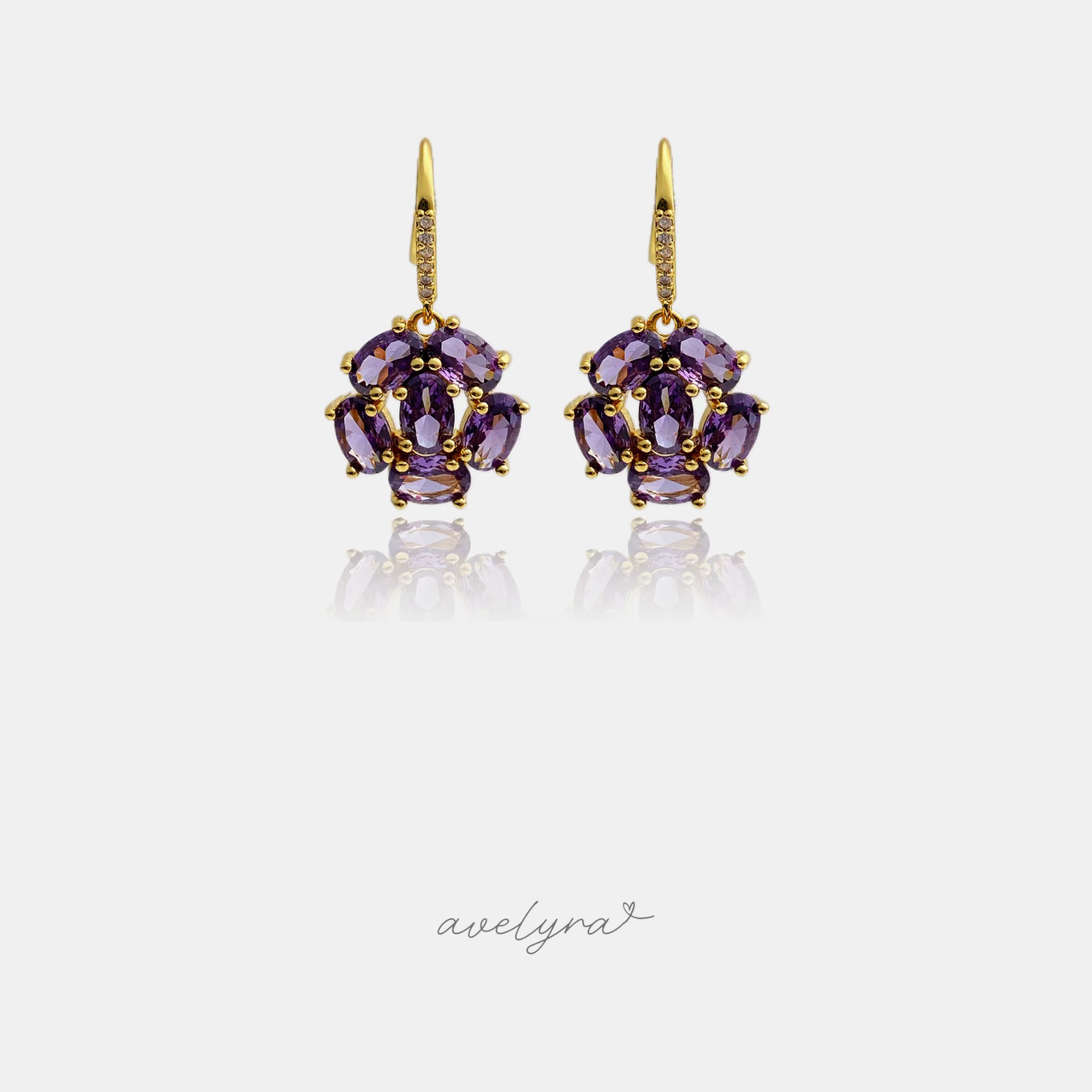 Gold-tone hook earrings with a cluster of oval purple stones.