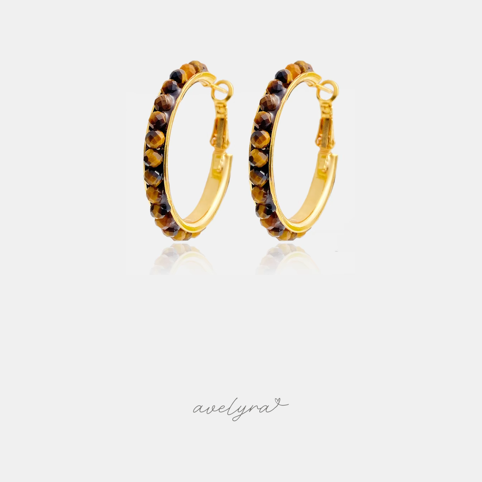 Gold-tone hoop earrings lined with warm brown shimmering beads.