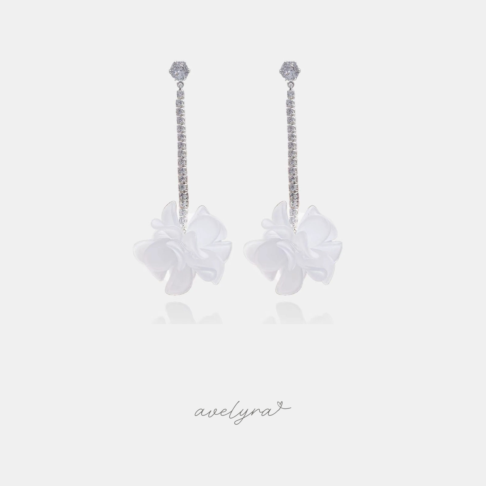 Long silver-tone crystal line earrings ending in soft white flowers.