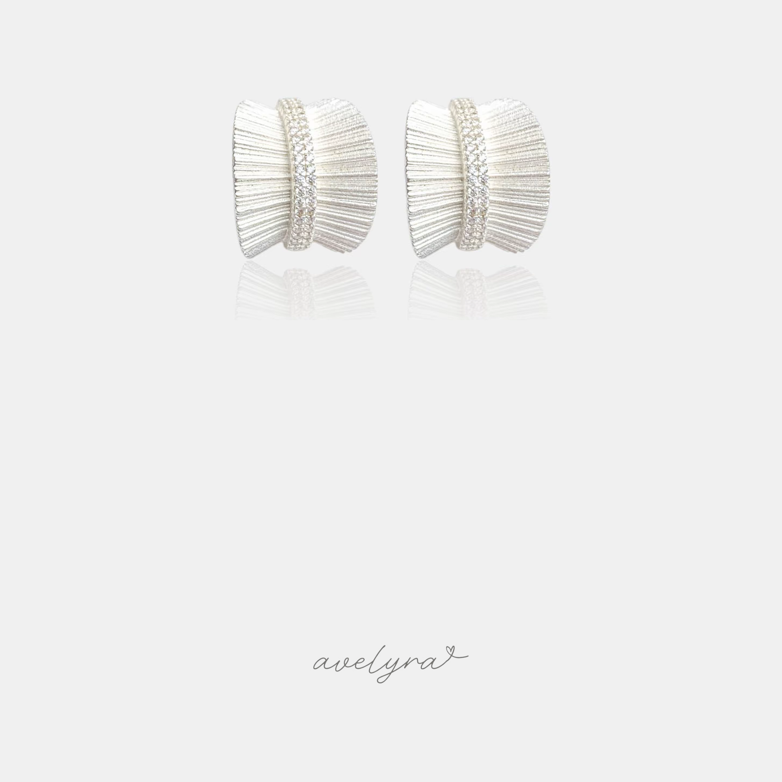 Silver-tone pleated fan stud earrings with a central band of small crystals.