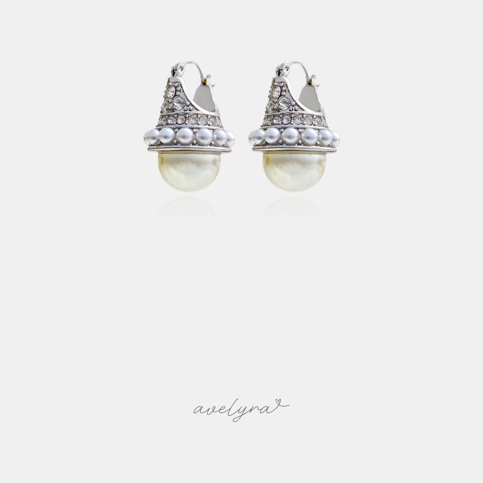 Silver-tone earrings with crystals and small pearls crowning a large cream pearl drop.