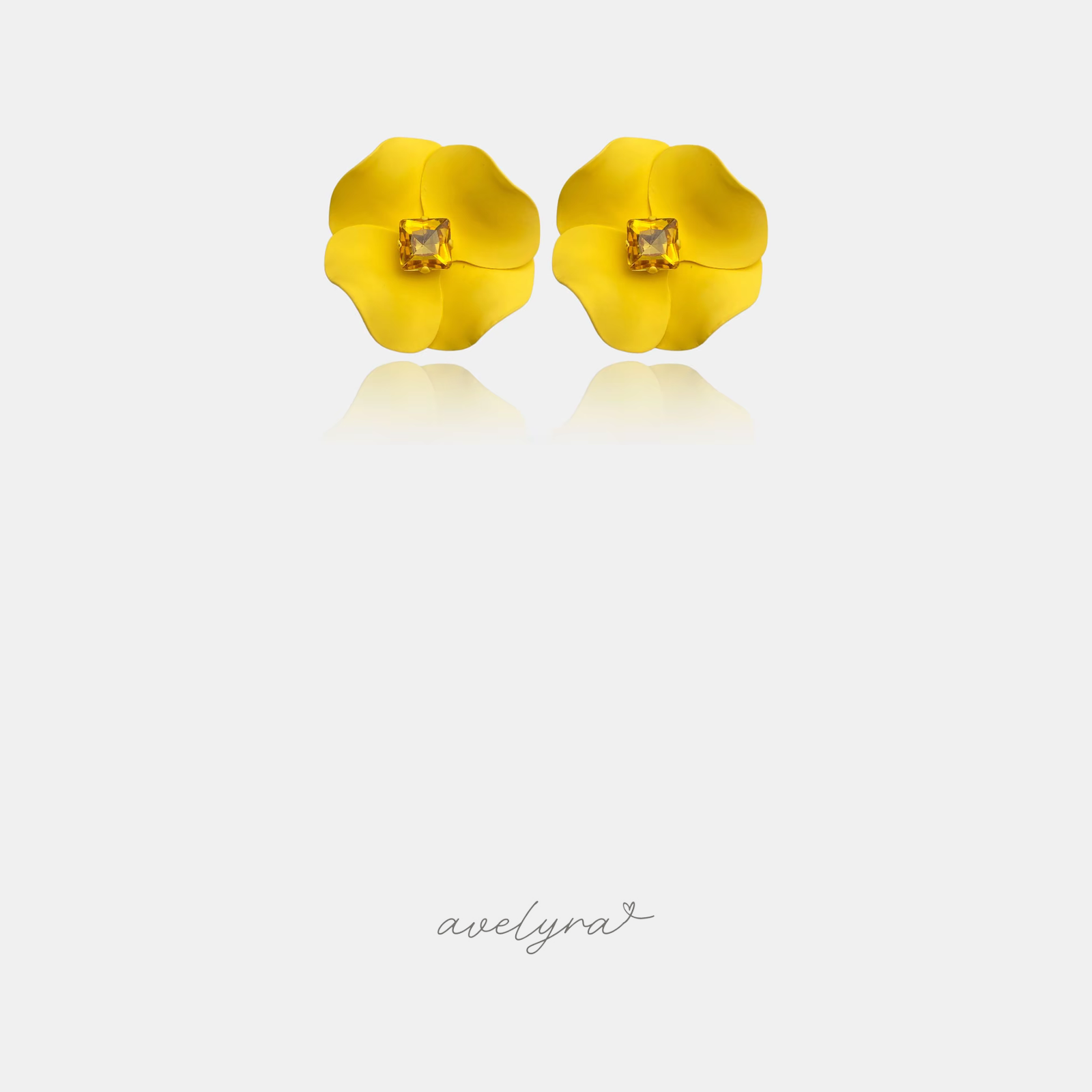 Matte yellow flower stud earrings with a square amber-coloured stone in the centre.