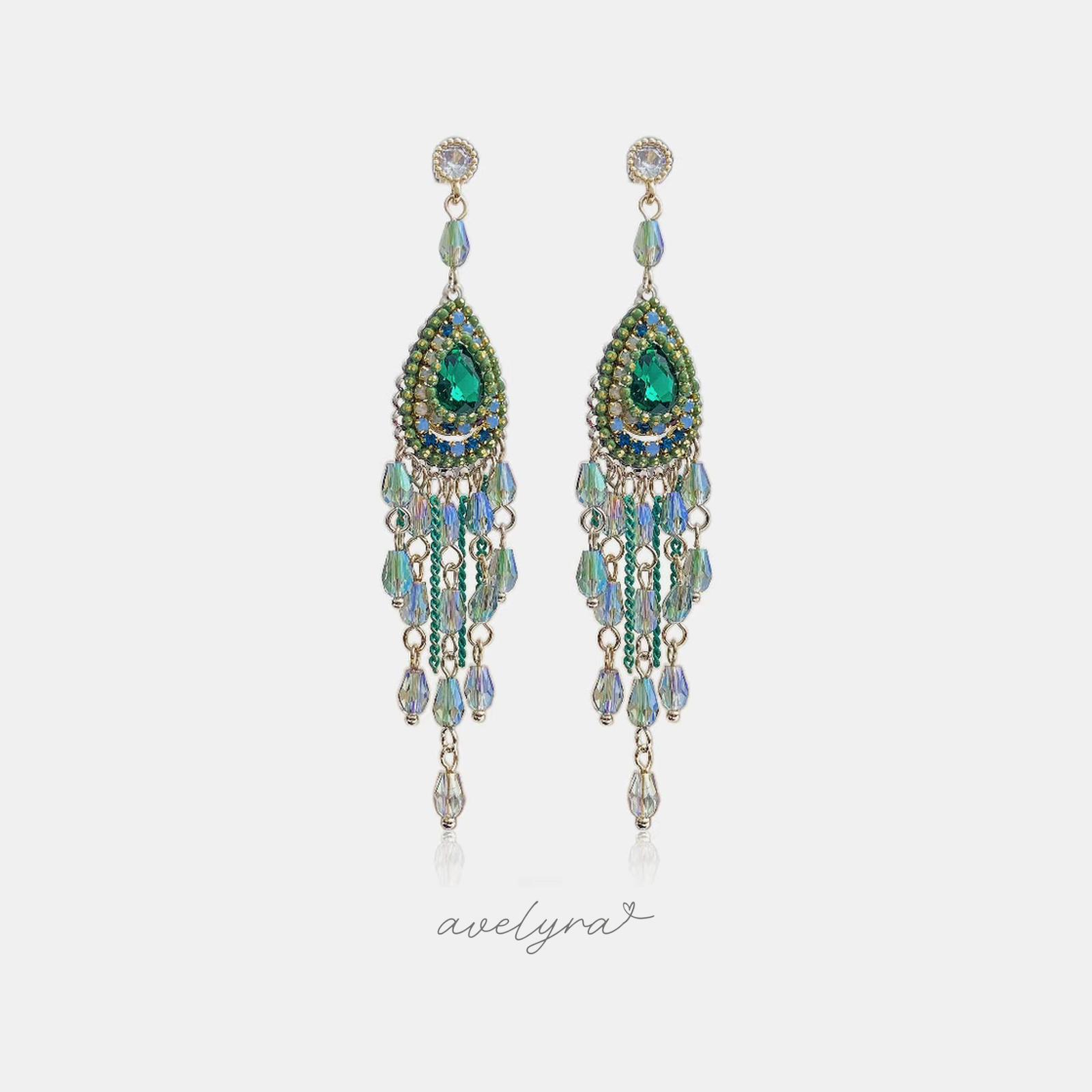 Long green chandelier earrings with a pear-cut green stone and cascading beaded fringe.