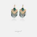 Chandelier earrings with a green pear stone, golden fan of clear stones, and green chain tassels.