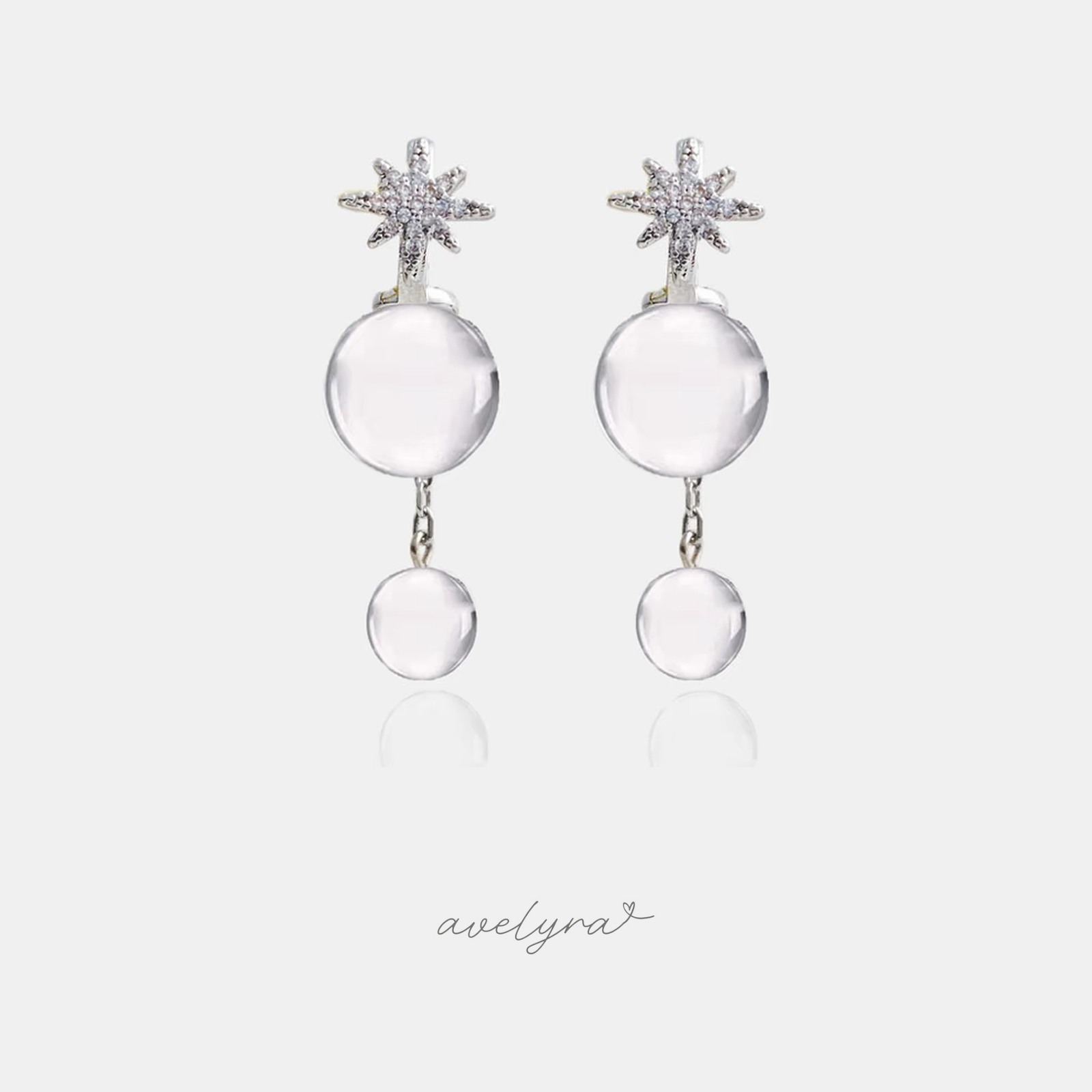 Dangle earrings with a sparkling starburst top and two clear round glass orbs.