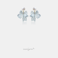 Powder-blue openwork bow earrings with a clear centre stone hanging beneath a white pearl.