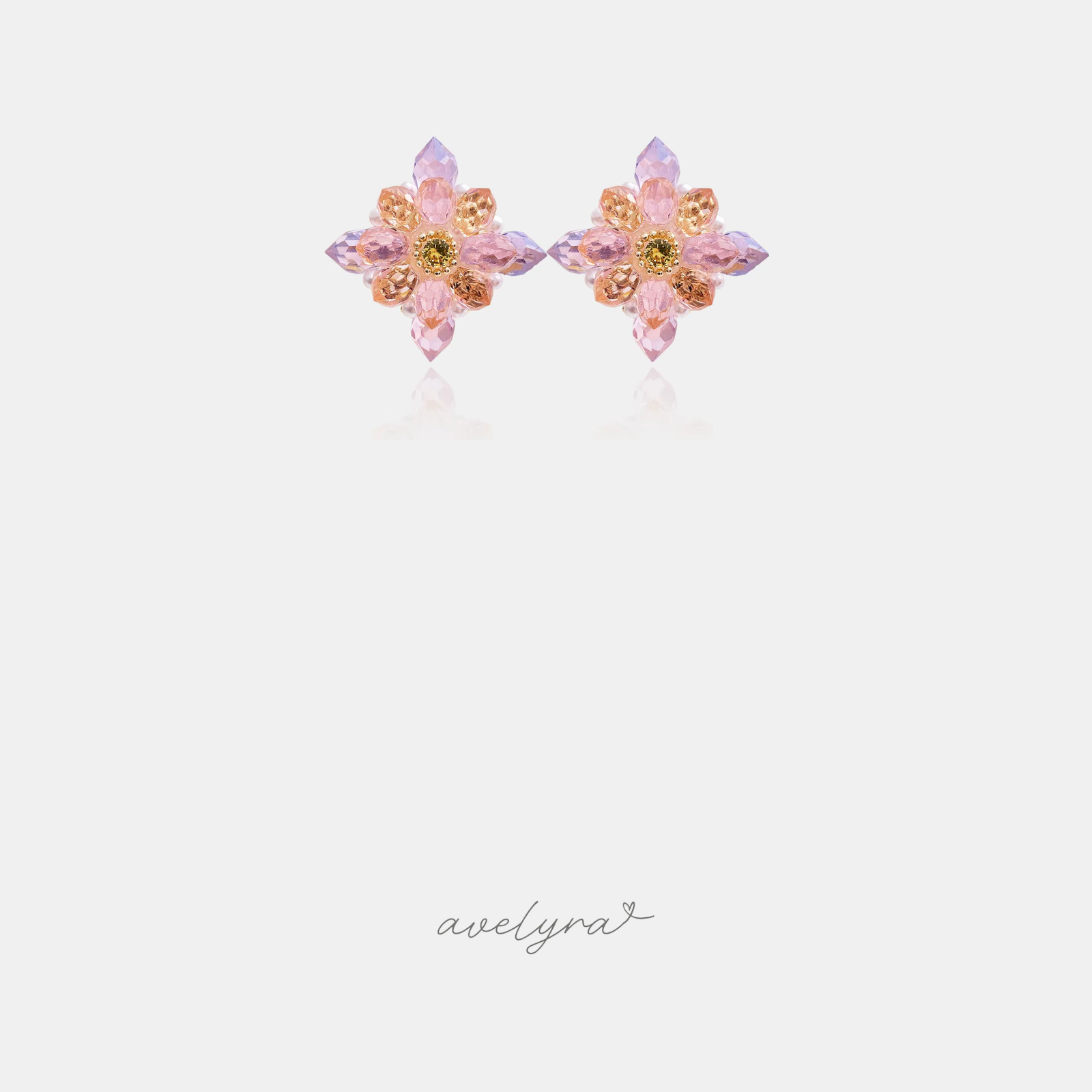 Pair of flower stud earrings with faceted pink, lilac and amber crystal petals around a golden centre stone.