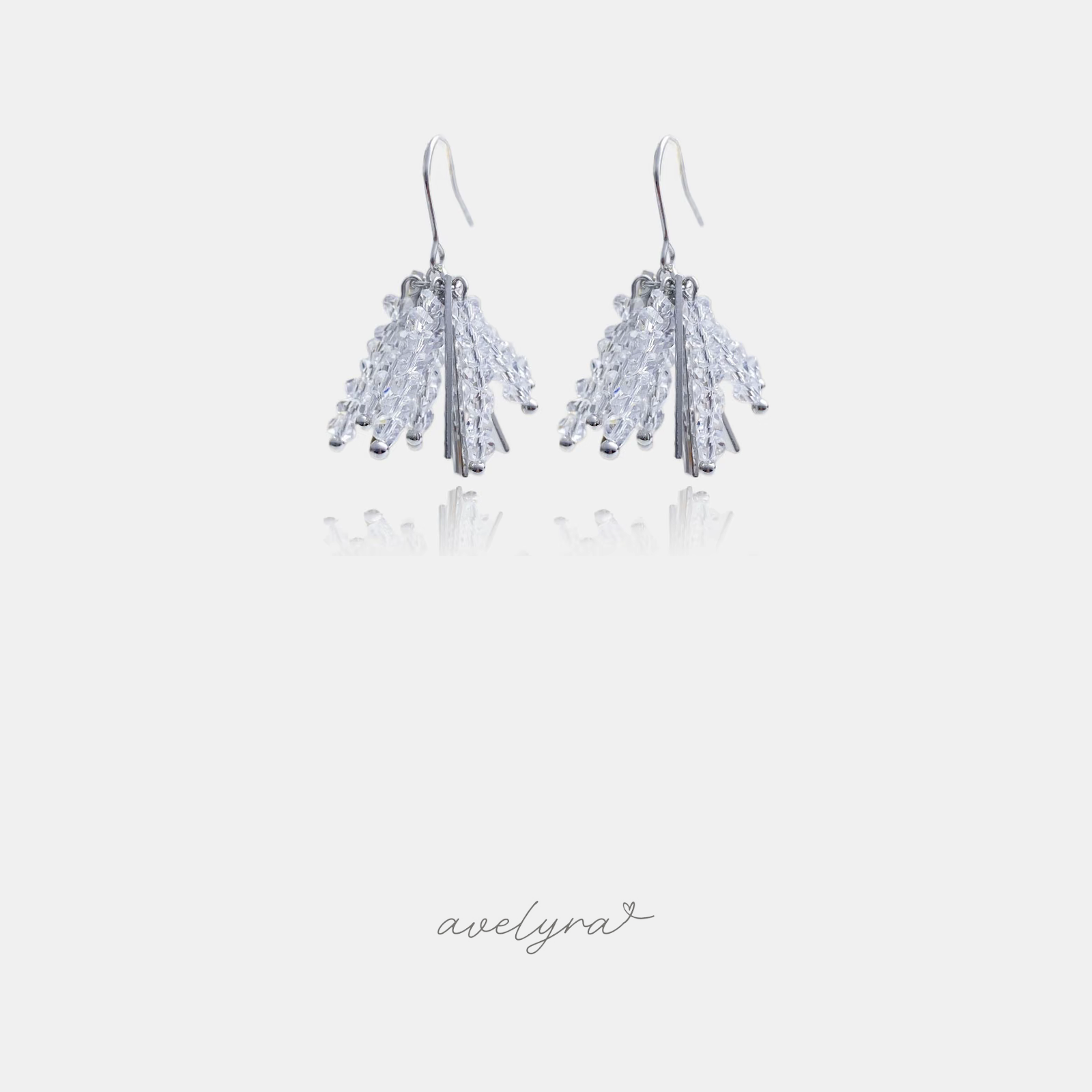 Pair of silver-tone hook earrings with a dense cluster of small clear faceted crystals hanging below.
