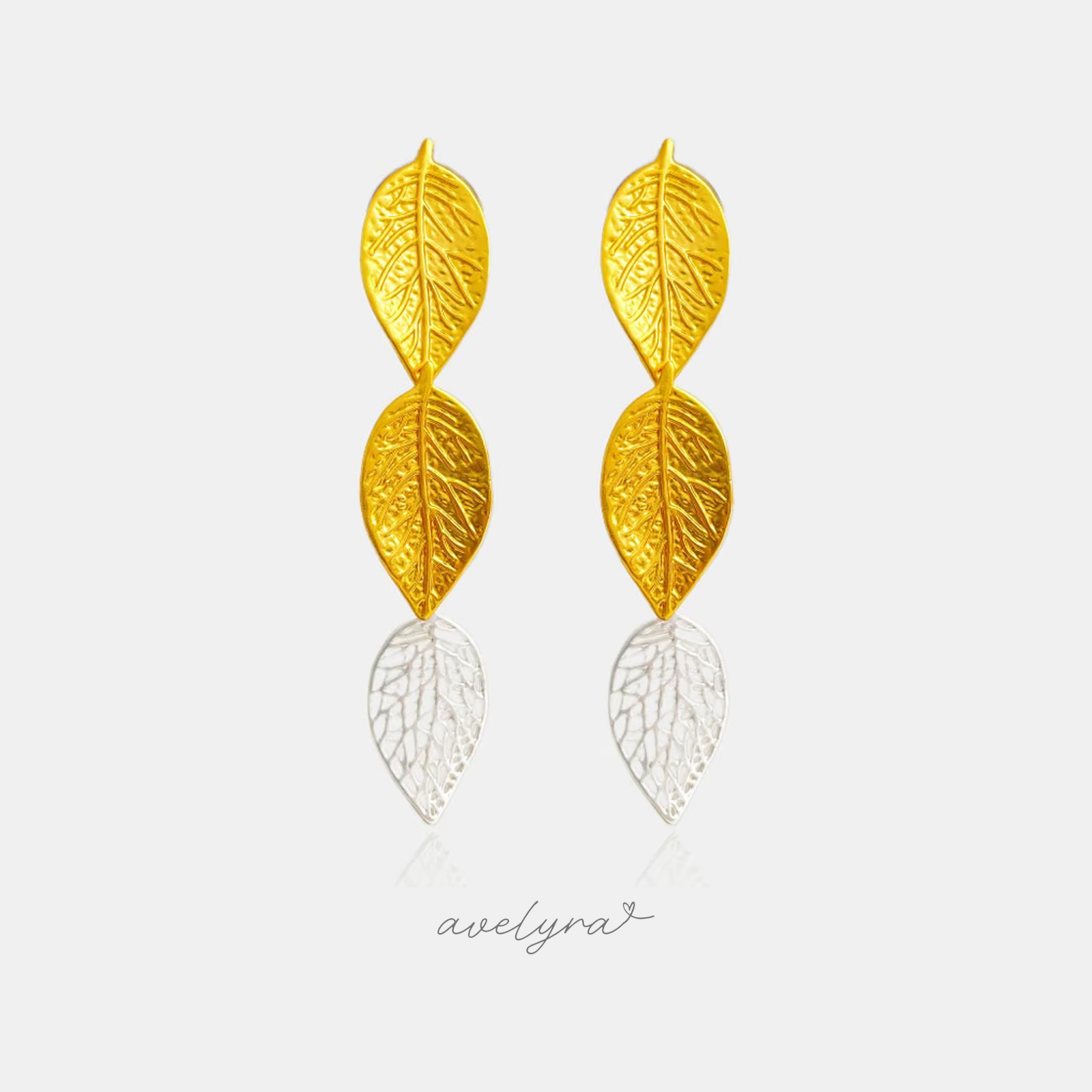 Gold-tone drop earrings shaped as two textured leaves with pressed veining, hanging one below the other.