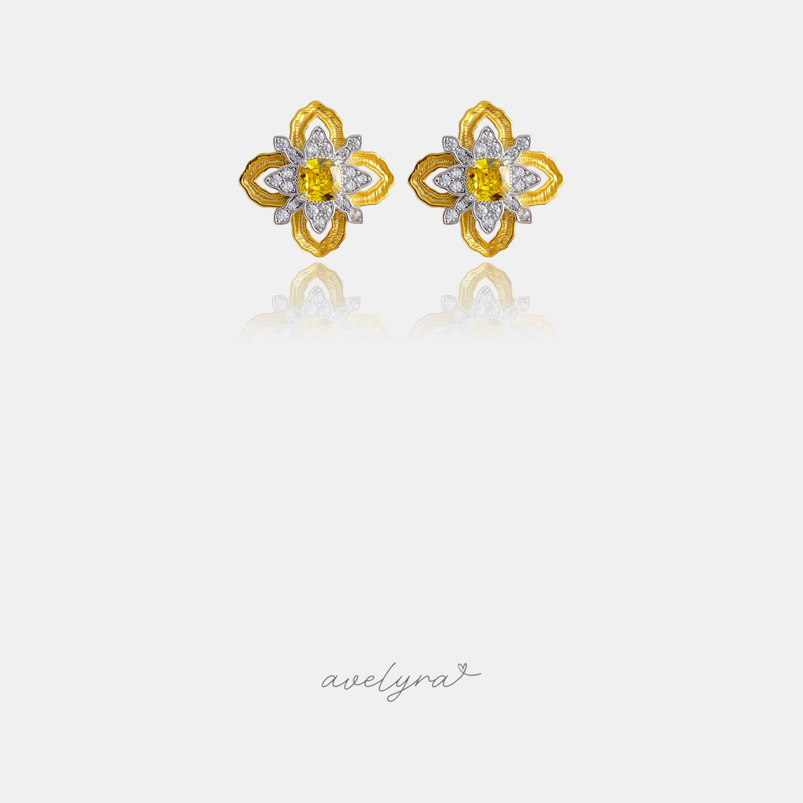 Gold-tone flower stud earrings with pave petals and a square yellow stone at the centre.