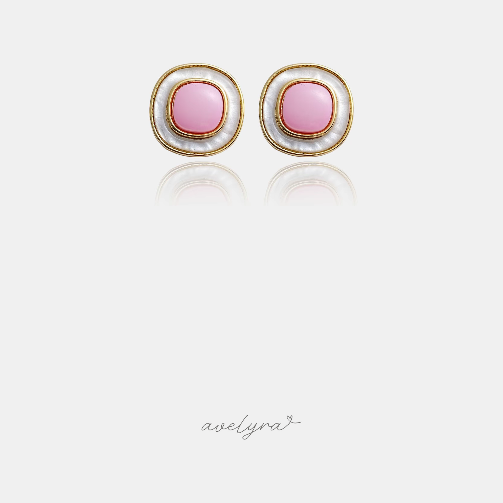 Gold-tone rounded button stud earrings with a pink centre surrounded by a pearly ivory ring.