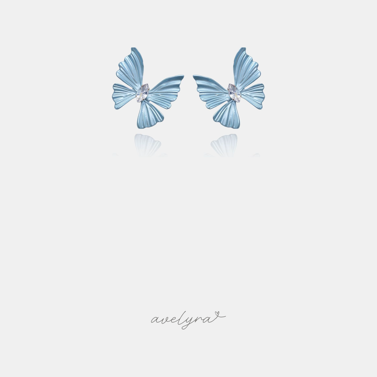 Powder-blue butterfly stud earrings with a clear marquise crystal at the centre.