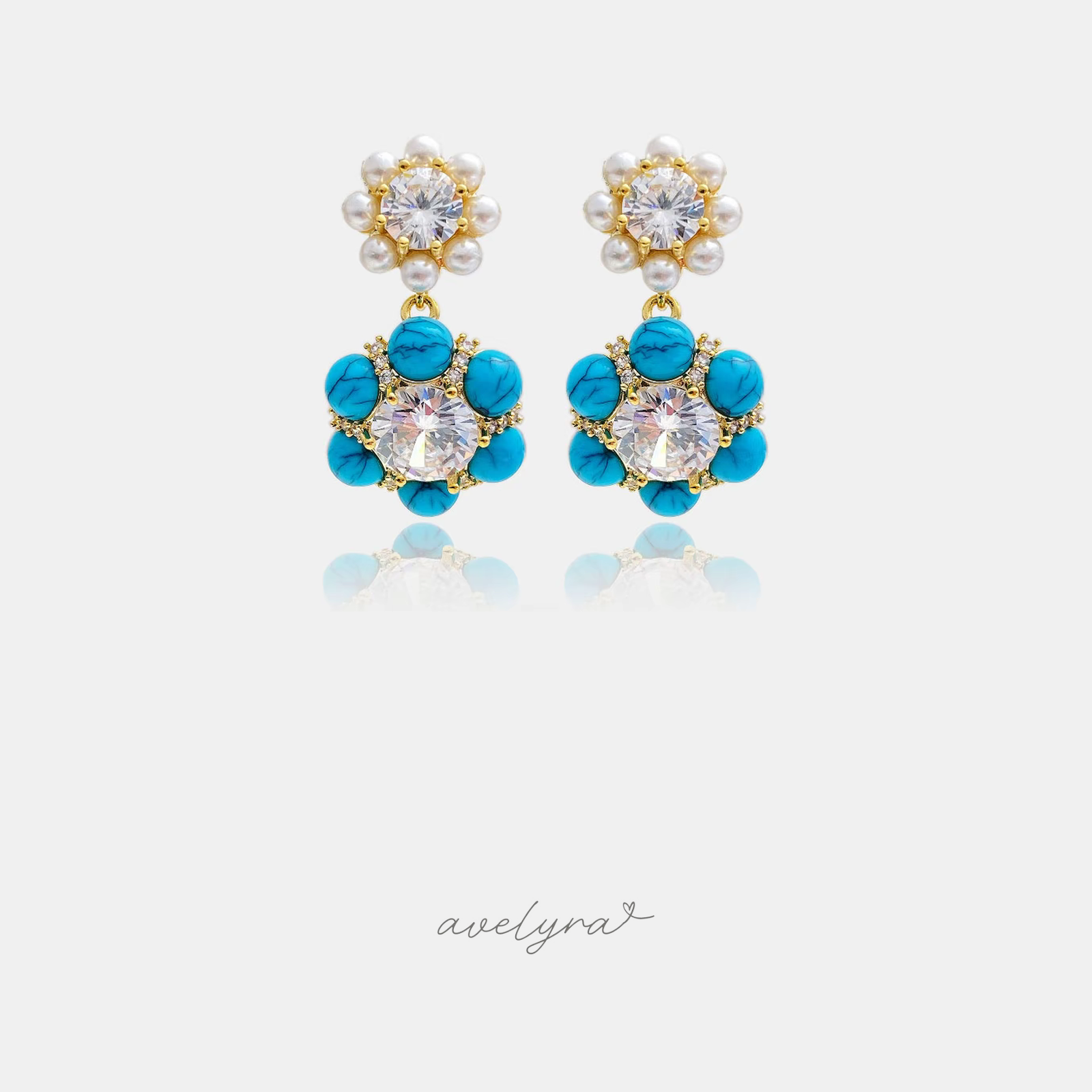 Gold-tone drop earrings with a pearl flower top and turquoise-blue stone flower with crystal centre.