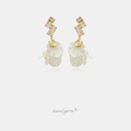 Gold-tone dangle earrings with clear baguette crystals and frosted ivory veined petal clusters.
