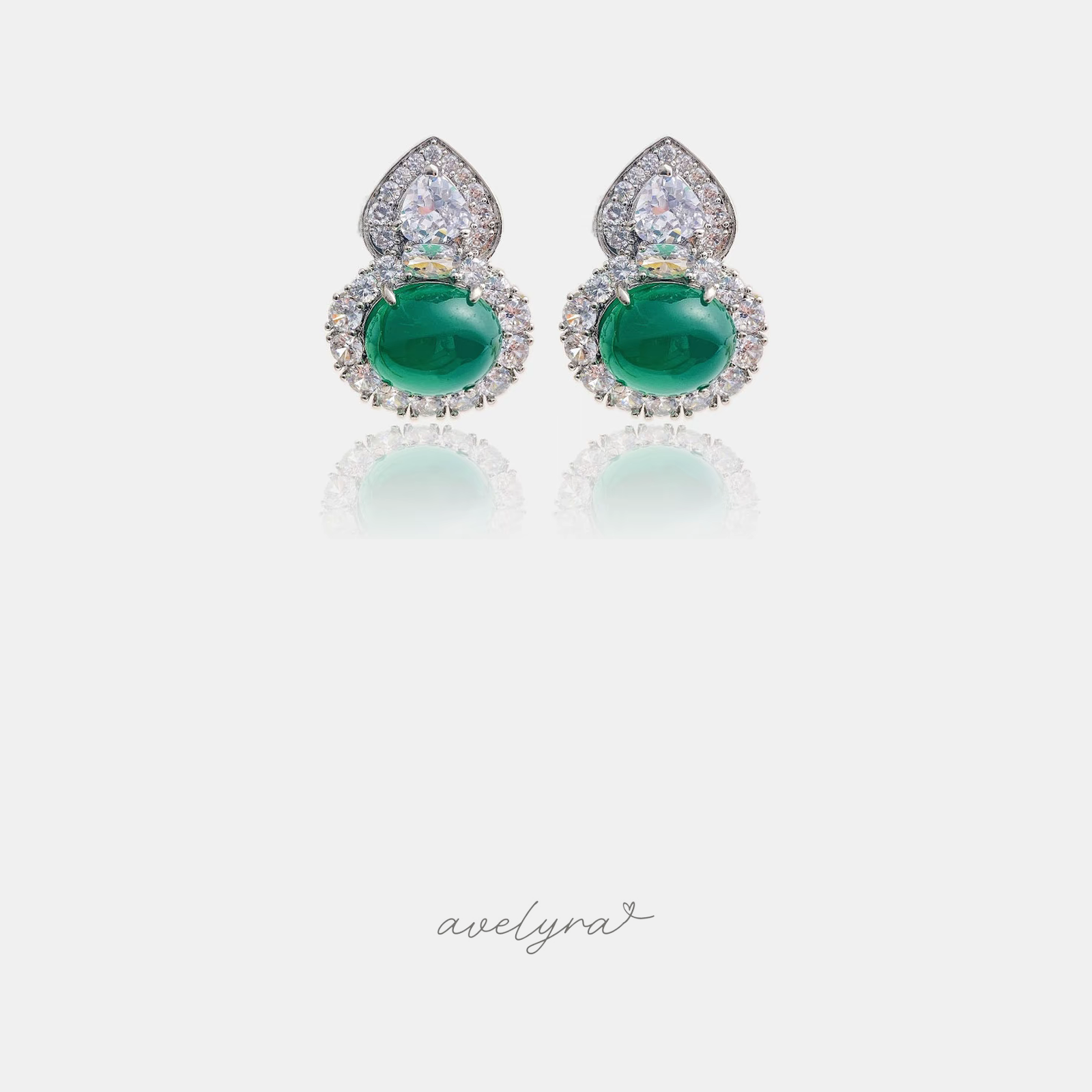 Silver-tone stud earrings with a green oval cabochon, crystal halo and teardrop crystal top.