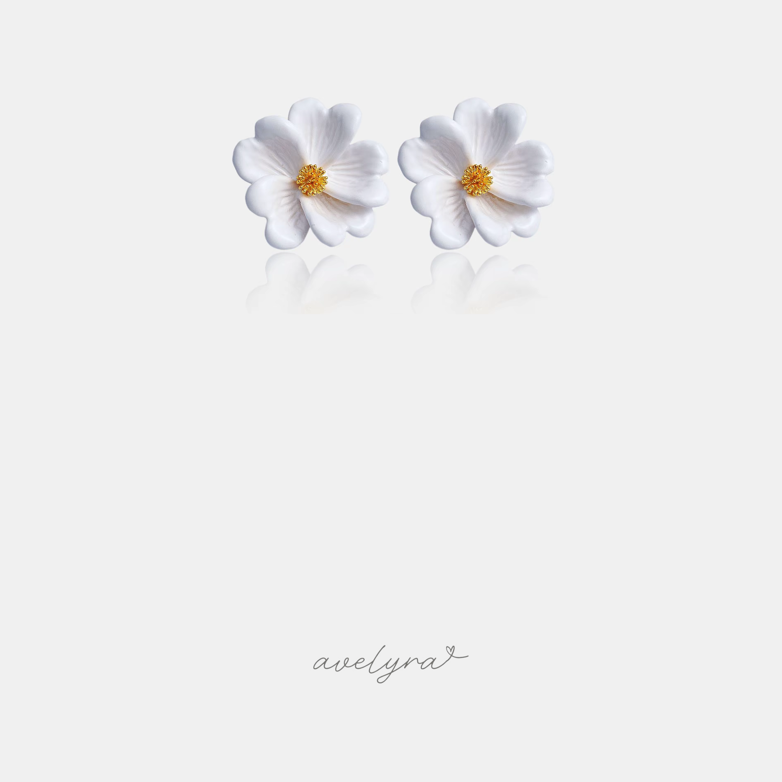 White sculpted flower stud earrings with curled petals and a gold-tone textured centre.