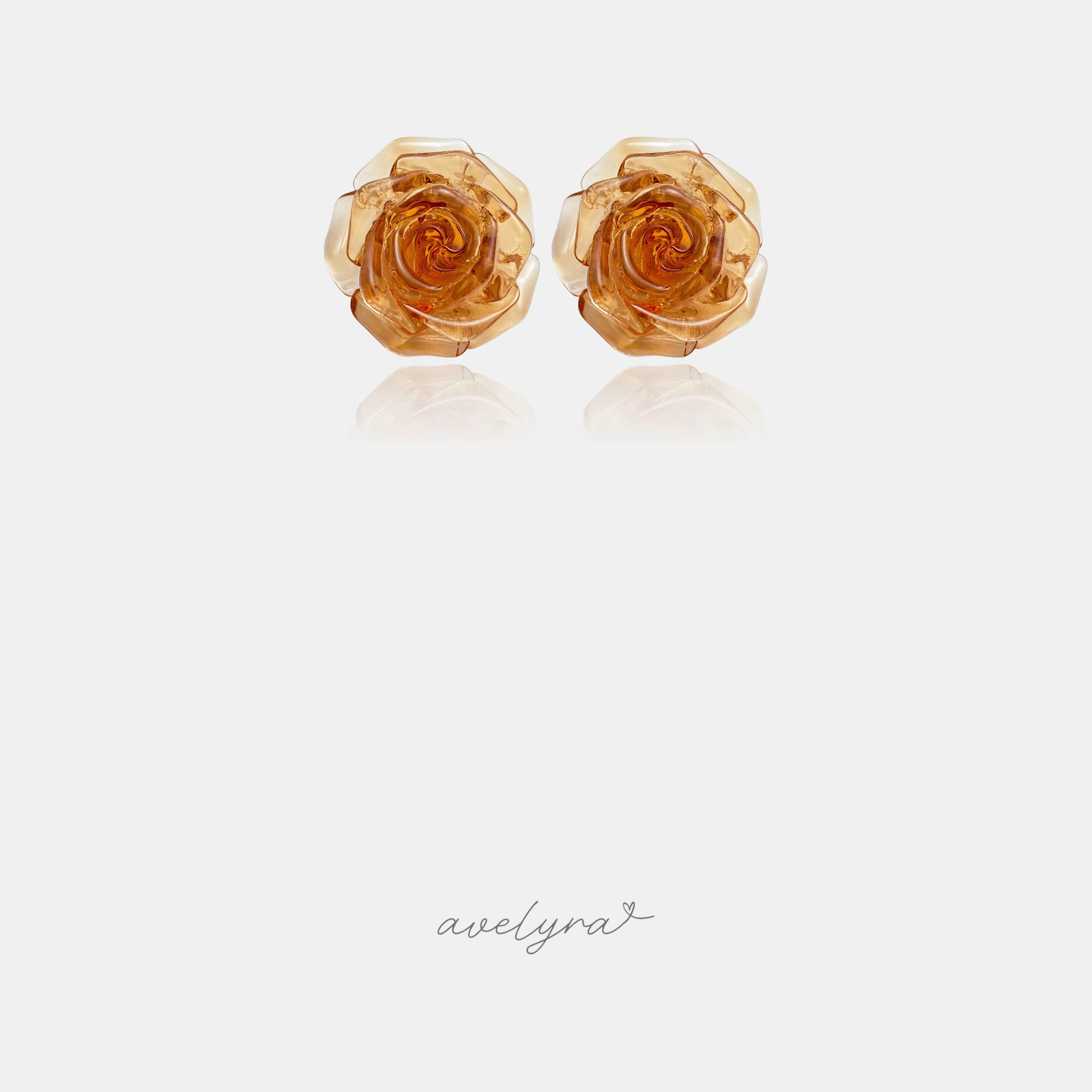 Translucent amber-orange carved rose flower stud earrings.