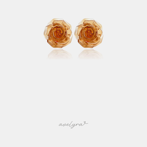 Translucent amber-orange carved rose flower stud earrings.
