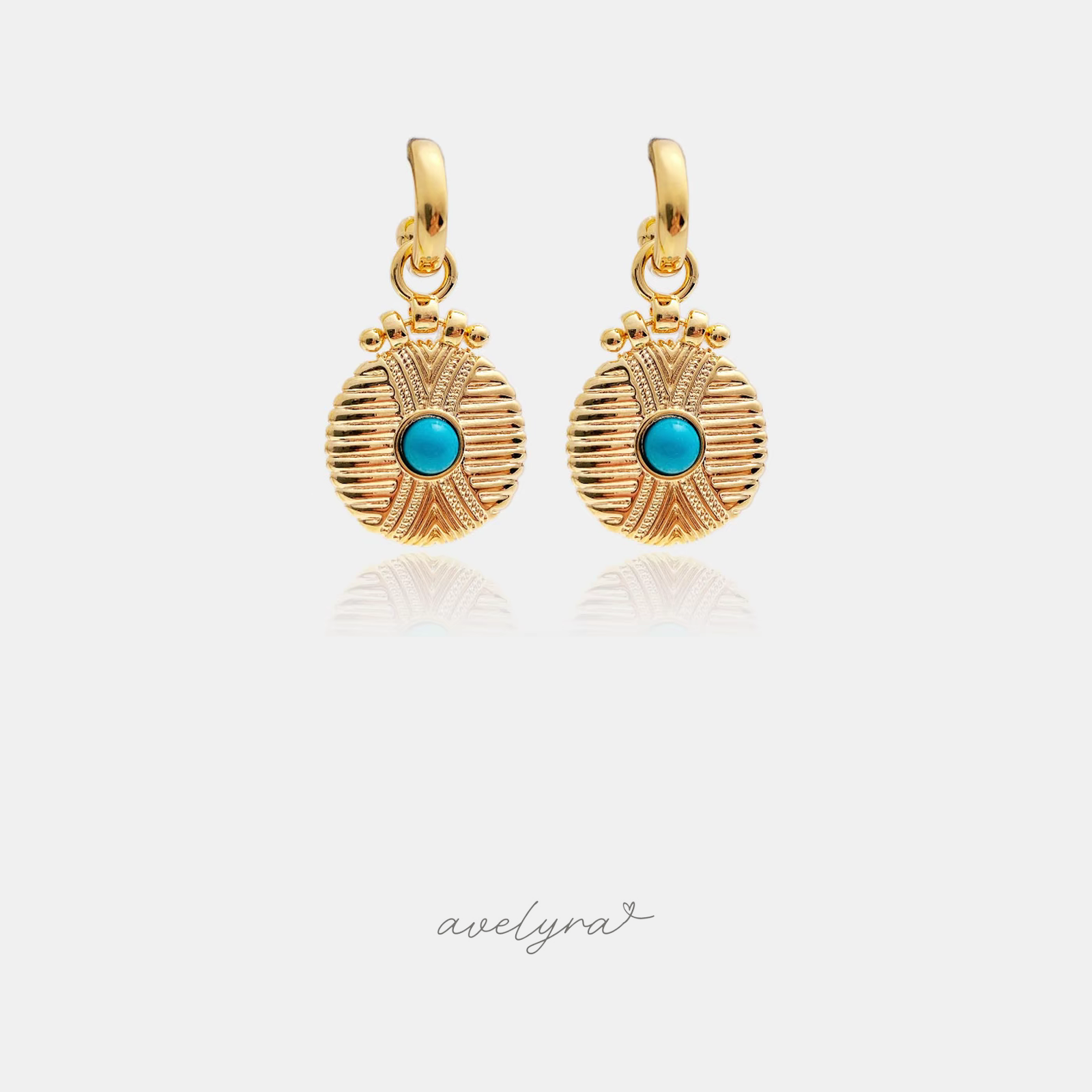 Gold-tone huggie hoops with engraved sunburst coin drops and a turquoise-blue centre stone.