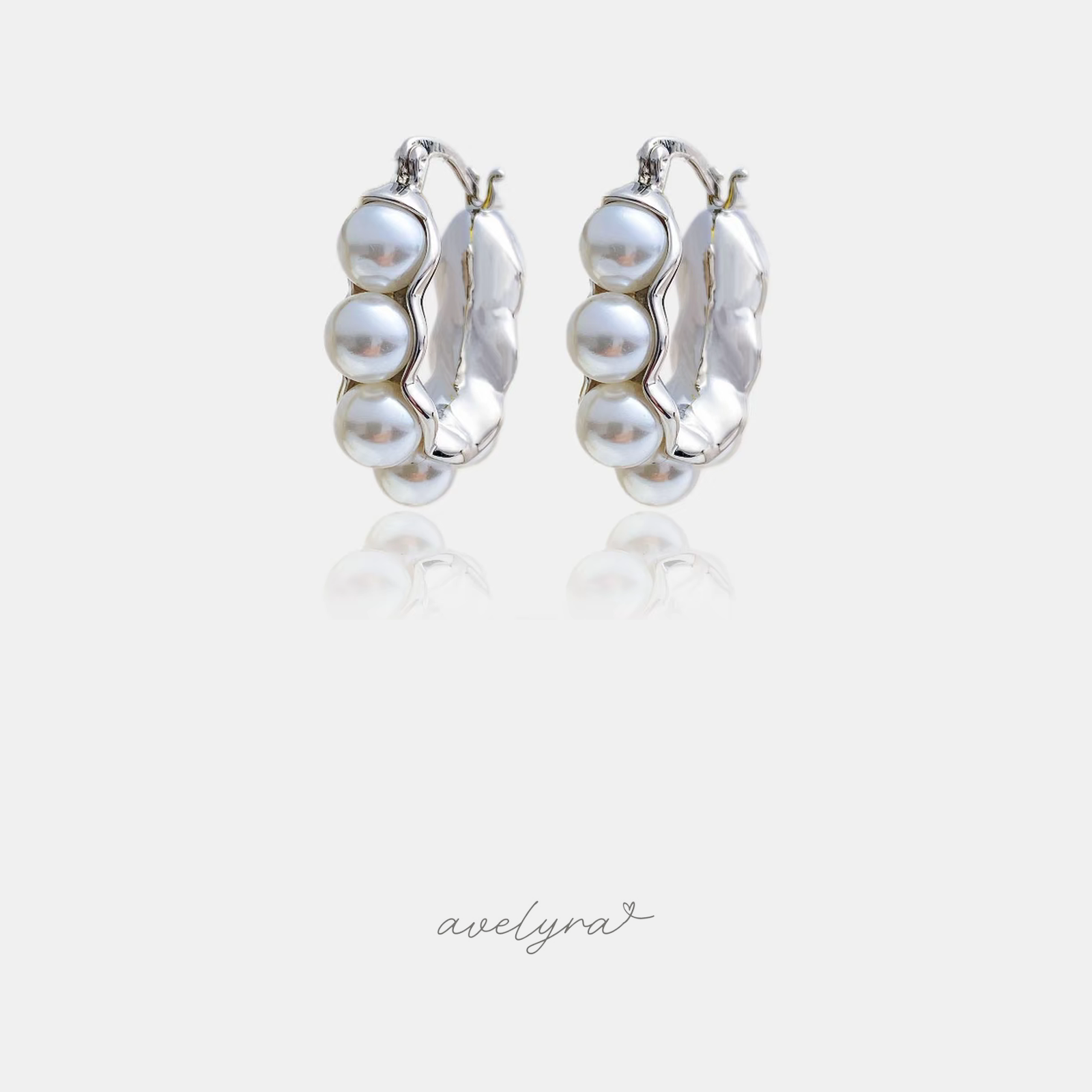 Silver-tone hoop earrings lined with rows of white pearls.