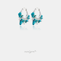 Silver-tone hoop earrings clustered with turquoise stone chips and white pearls.